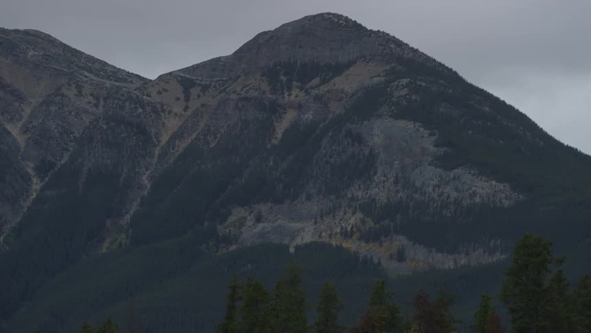 The tall mountain ahead has heavy clouds above