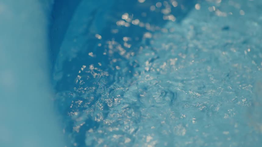 A closeup of a pool being filled with water