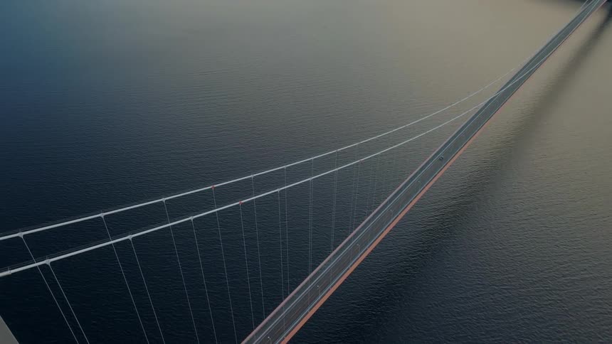 Aerial view of a massive bridge above the sea with only one vehicle traveling