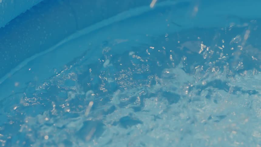 Closeup of water droplets falling into a pool