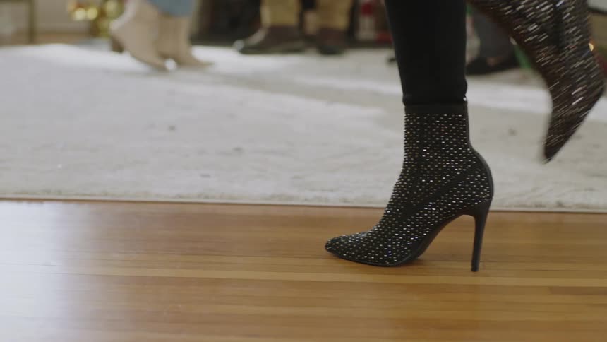 Heeled boots walking across the wooden floor