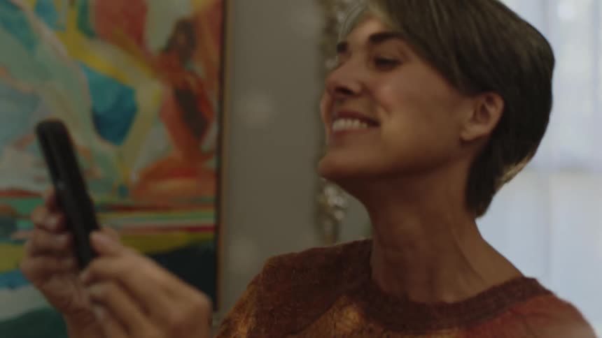 Friends dancing while another woman films them with her phone all happy and smiling