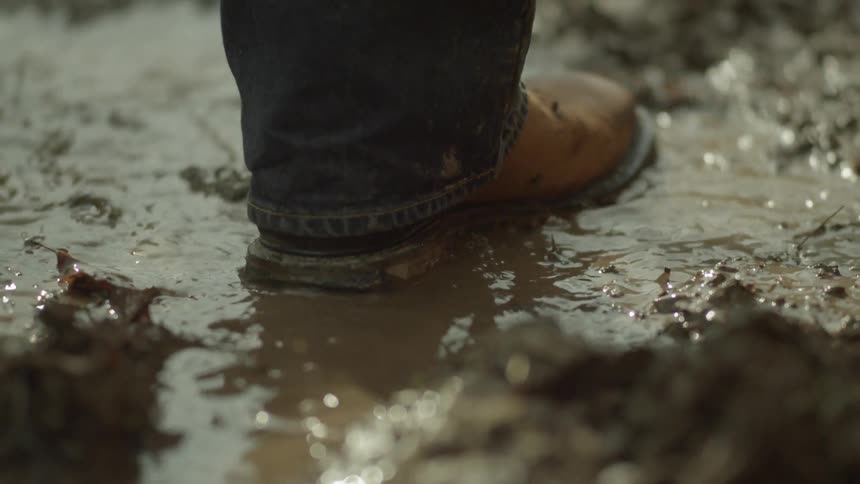 A person is walking in the mud