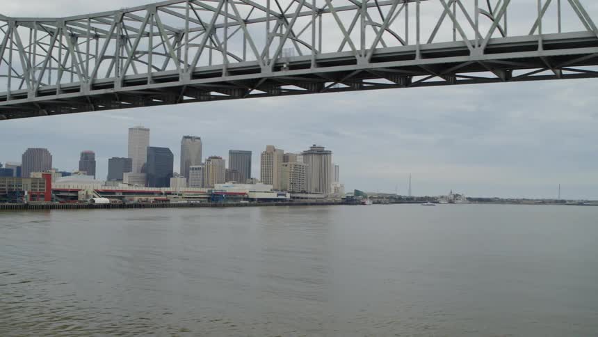 A city view from a nearby river with a twin steel bridge across the river