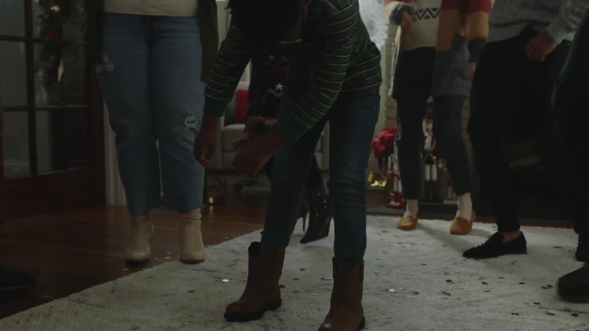 People dancing indoors in the living room during the christmas season