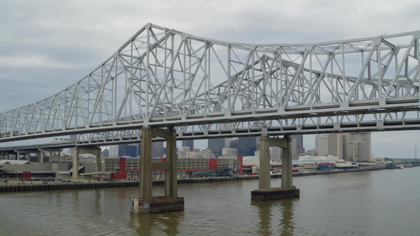 A twin steel bridge leading to a city with modern infrastructures and building on a cloudy day