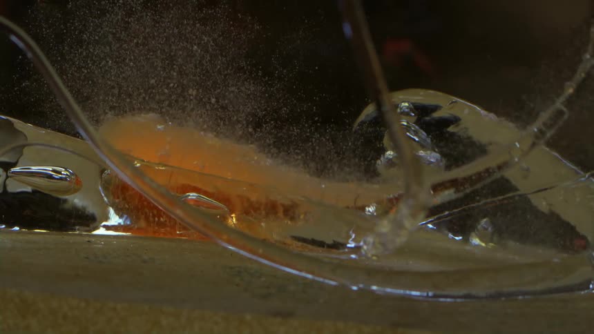 A drop of hot glass falls into water and boils it making bubbles