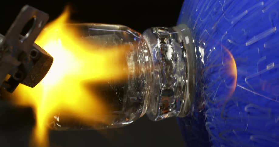 A glass vase is melting with the heat of the fire that is bringing it together with other glass