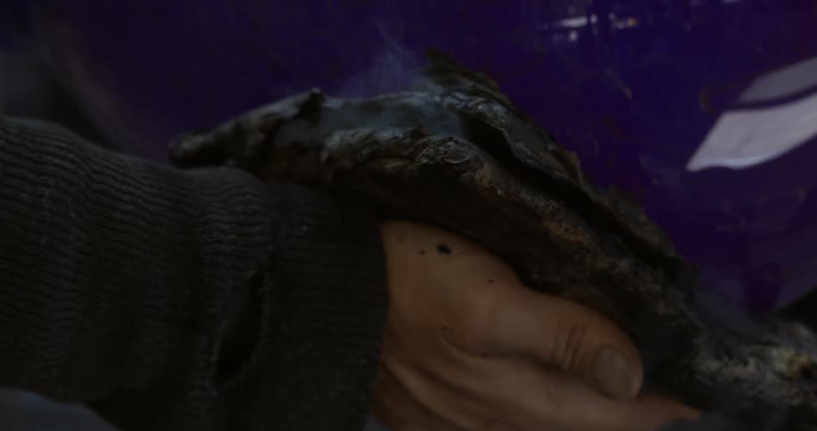 Man holds a piece of hot steaming glassware with a thick cloth