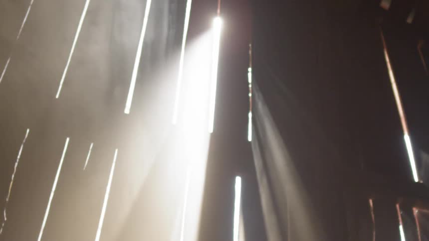 Dust hovering in sunlight that is streaming through the gaps in a barn wall