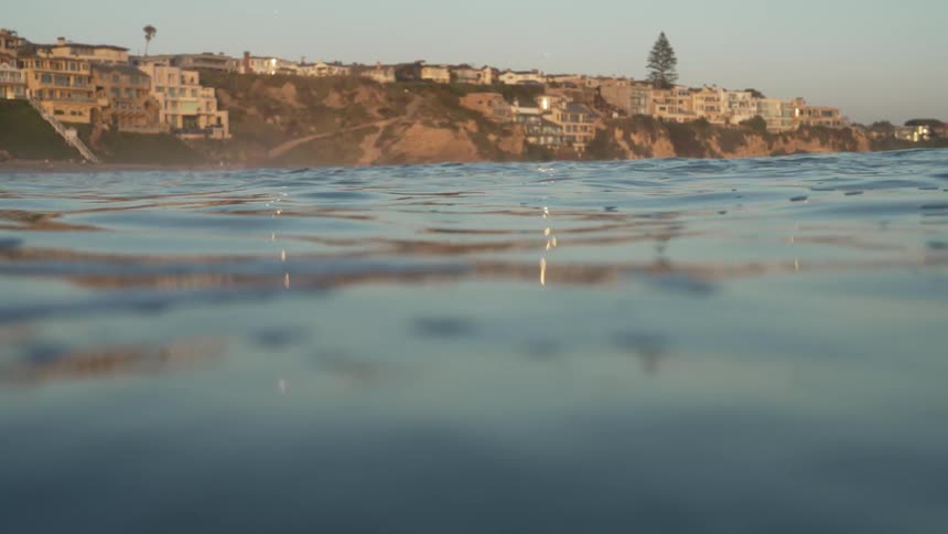 Seawater waving gently by a coastal mediterranean town