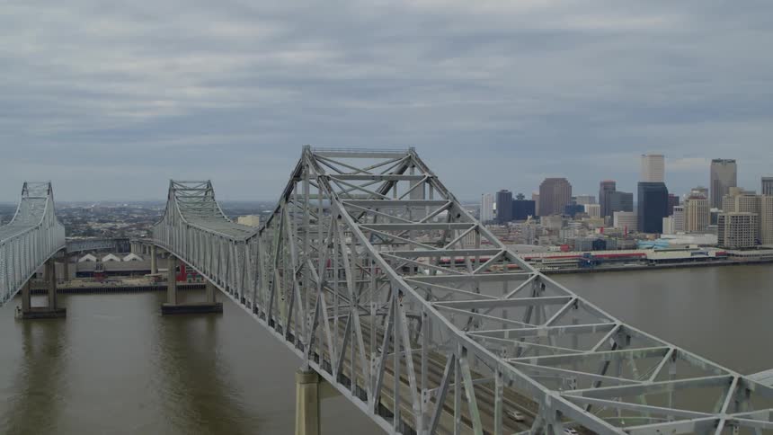 An aerial view of a metropolis by the sea with two enormous bridges