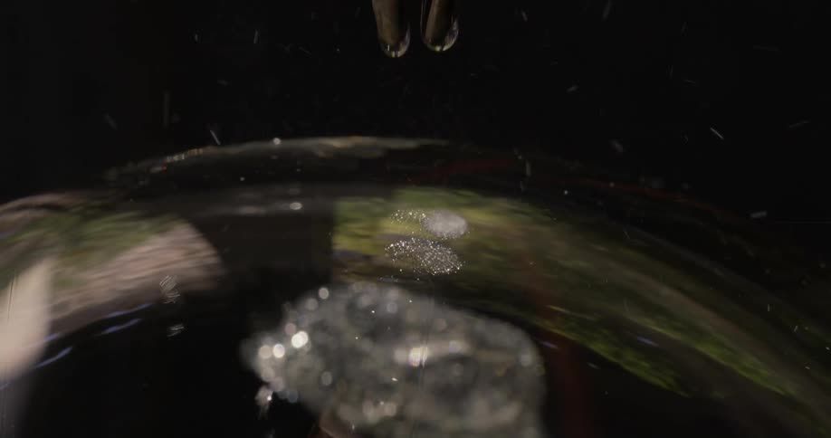 Drops of liquid are falling onto a round surface where they are exploding