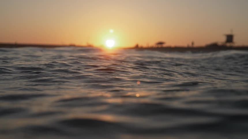 Water ripples and waves as light from the setting sun reflects on the surface