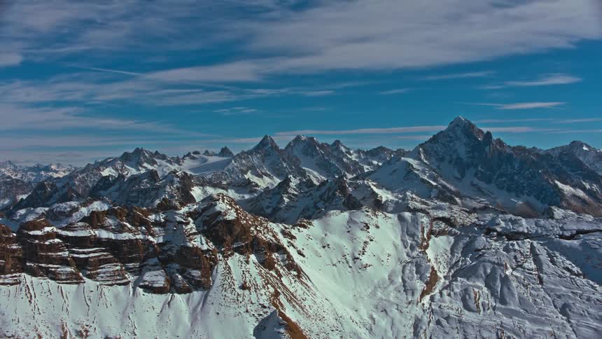 A mountainous region with several rock mountains with snowcapped peaks