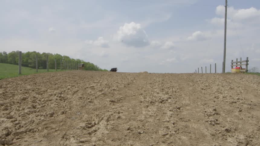 A field is filled with brown dirt and grass on the side