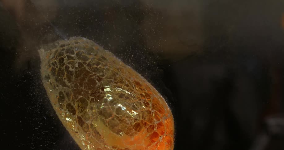 A piece of hot blown glass glassware cooling in water