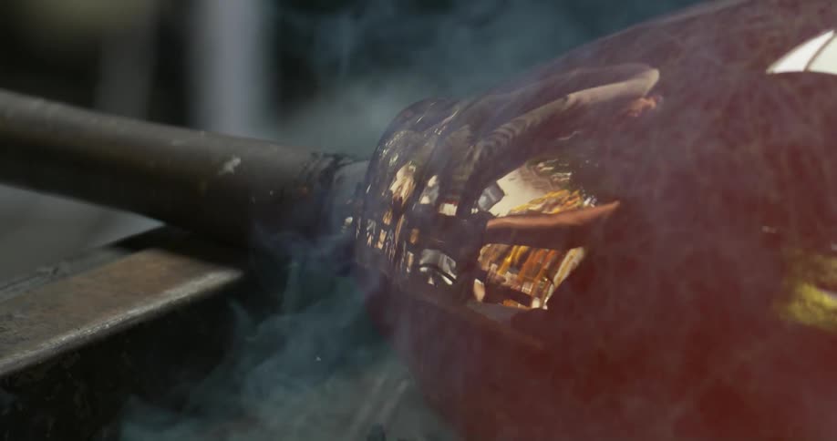 A glass sphere in production with smoke emitting