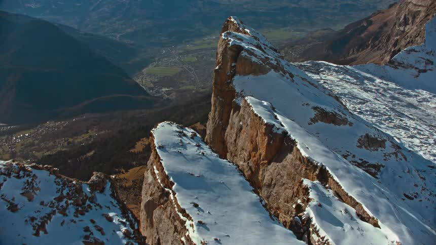 Snow frosted mountain slope towers over town in valley