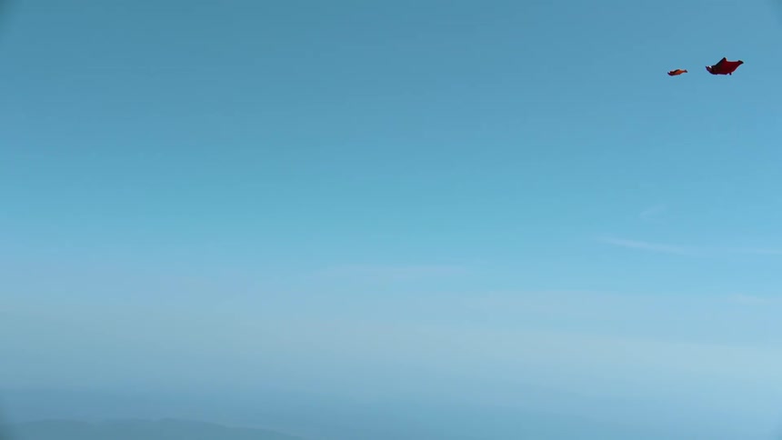 Two people flying in wingsuits