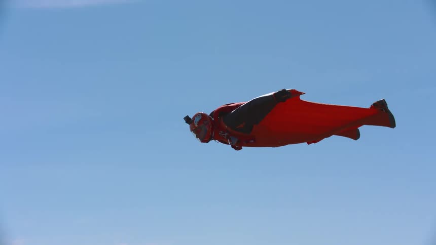 Person flies in sky wearing wingsuit