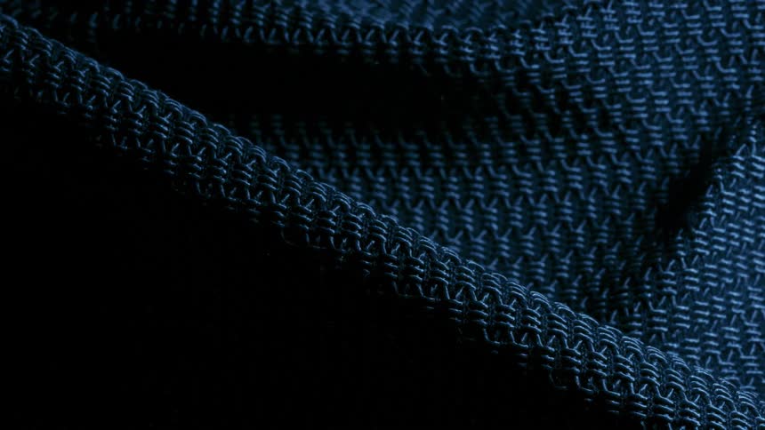 A blue fabric texture with patterns being illuminated in clusters
