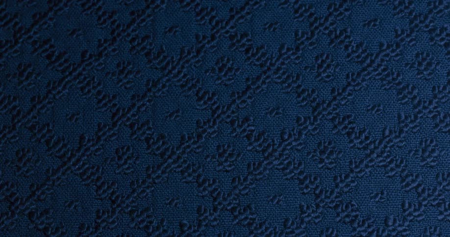 A patterned blue cloth texture is getting darker without light
