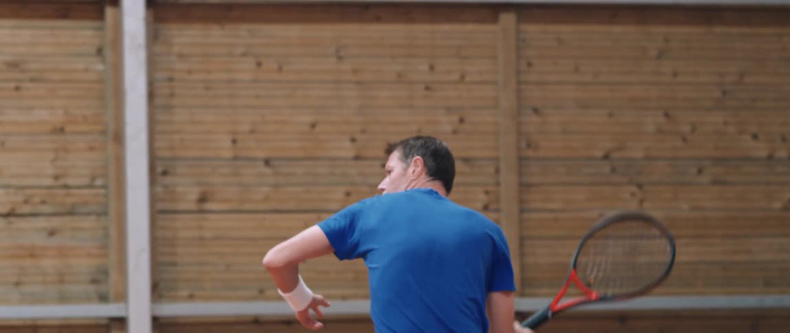 A man hitting a ball with a tennis racket