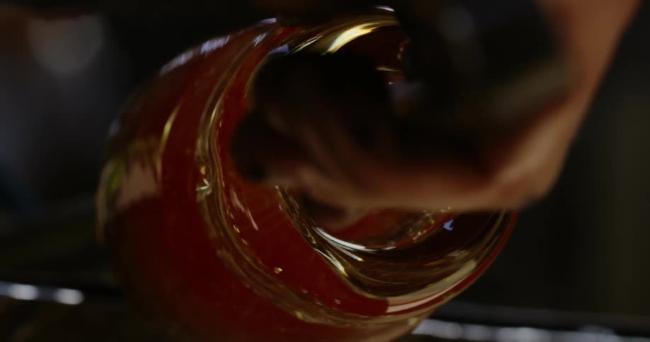 Glass maker shapes glass intocontainer with a tool