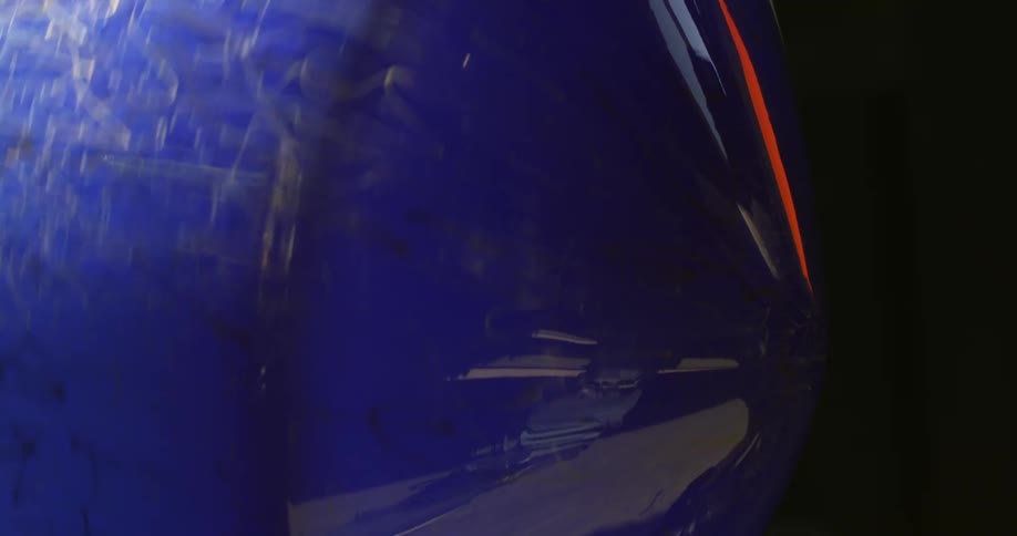 Gold decorated blue glass reflects person as it is rotated