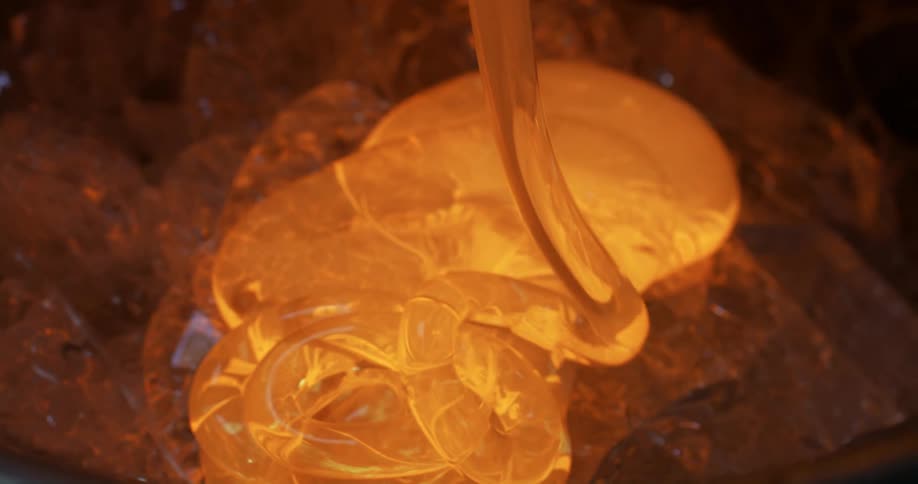 A closeup of glass in its liquid state being poured