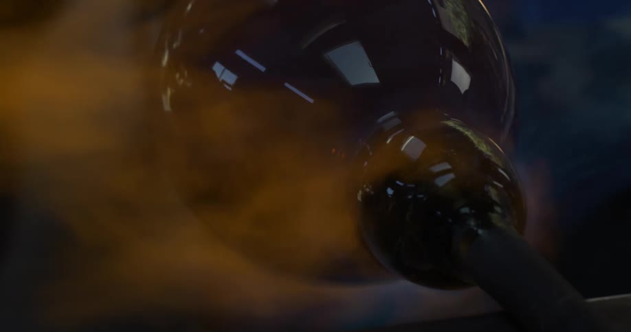 Glass is being shaped on a tube in fire