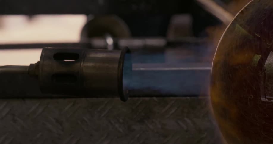 Glass vase in a blowpipe turning under the flames from a torch