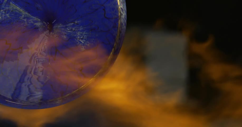 Circularshaped blue glass being shaped in fire