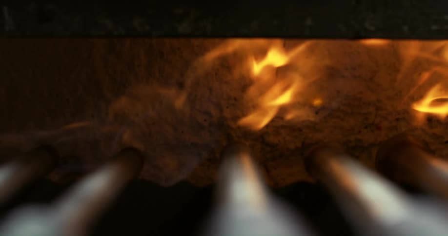 Flames rise from the bottom of an oven or furnace