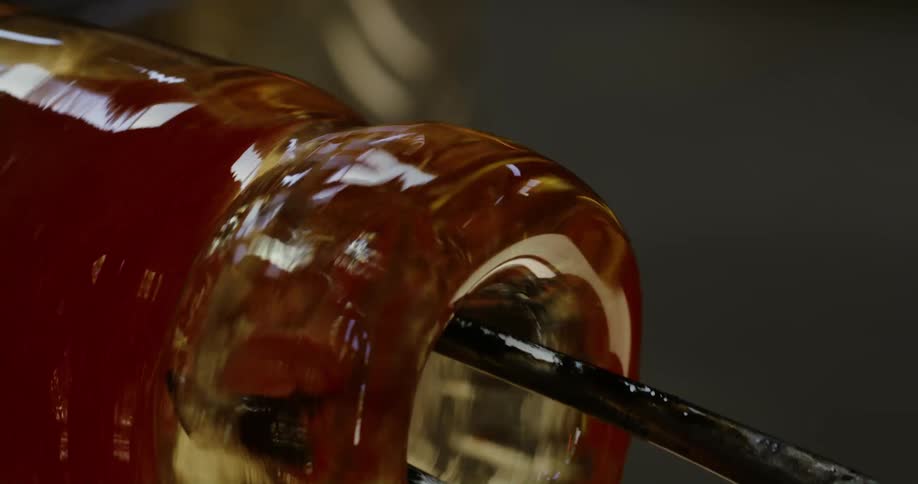 Close up of a tool performing the finishing of a glass bottle