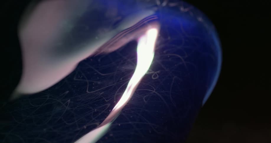 Light shines and reflects over the blue surface of a piece of glassware