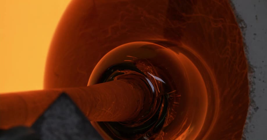 Molten glass rotates in furnace at end of staff