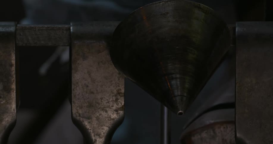 An iron funnel hangs with smoke rising from its surface