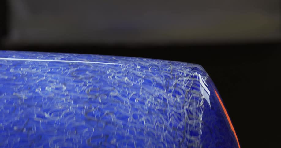 A blue vase spinning in a dark room with faint light shinning on it