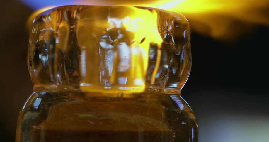 A crystal object being shaped and finished by a torch with fire