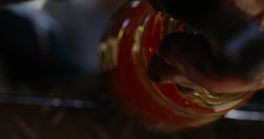 A person is squeezing a glass jar that is melted and is molding it
