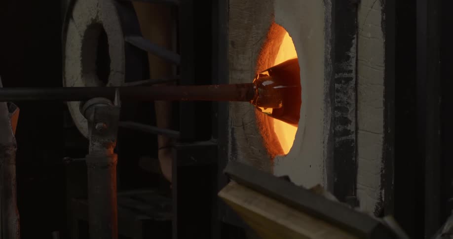 A piece of glassware turning inside a hot furnace