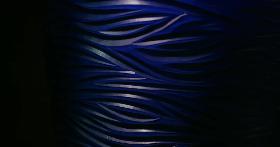 A time lapse from day to night is reflected onto a piece of wood with wavy lines