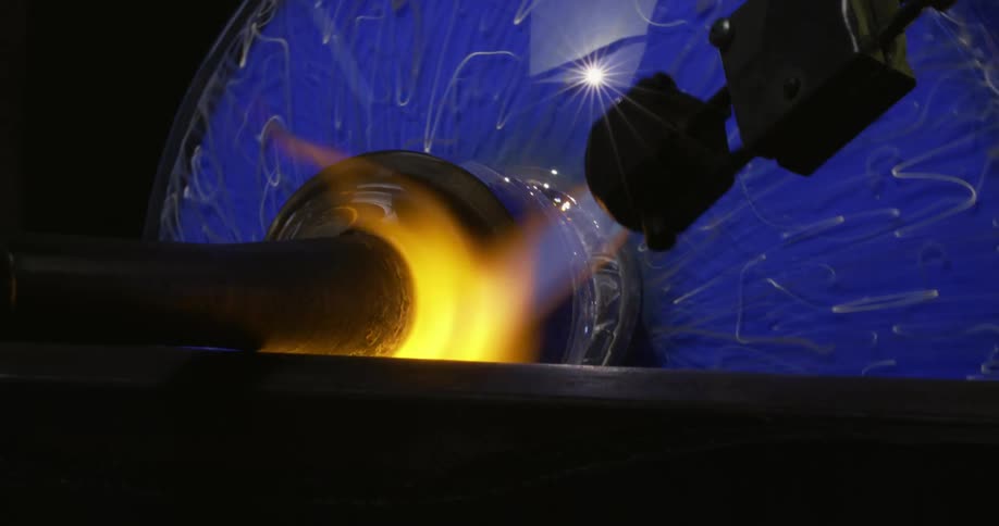 A glass vase being melted by a toch