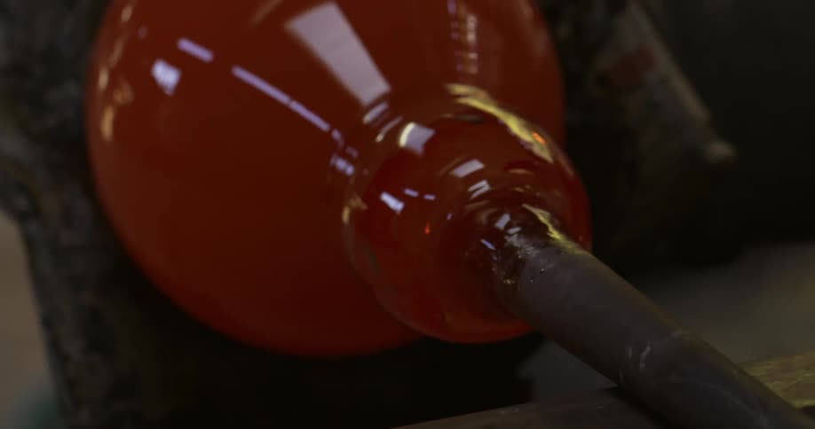 A vase being molded is so hot that it is orange and is spinning