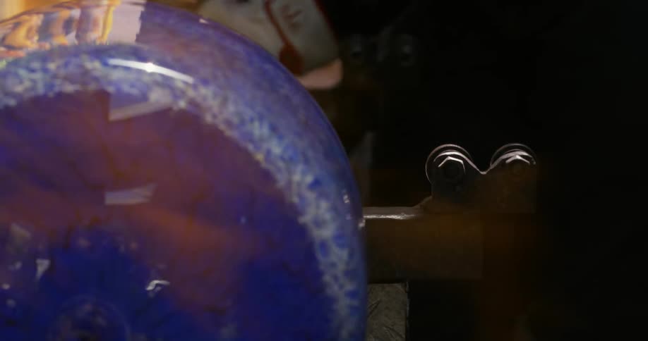 Production of a glass vase with fire finishing the details