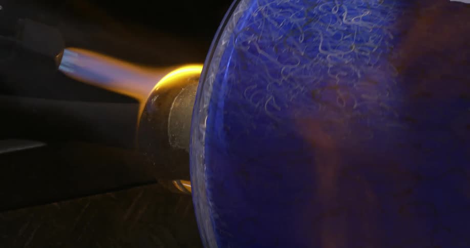 A blowtorch heats a metal rod connected to a spinning cylinder