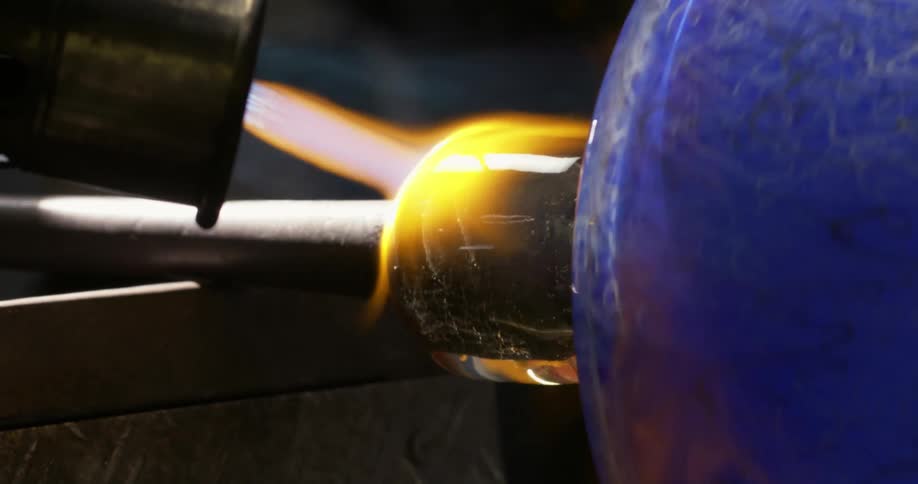 Blowtorch being applied to the molds of a blue glass jar