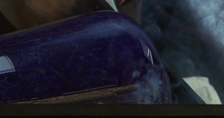 A rotating glass vase is emitting smoke because it is hot